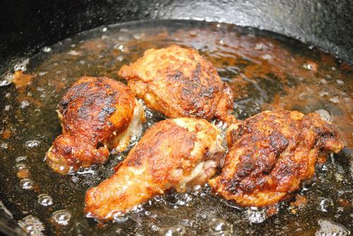 Kip koken in een koekenpan met groenten en kruiden